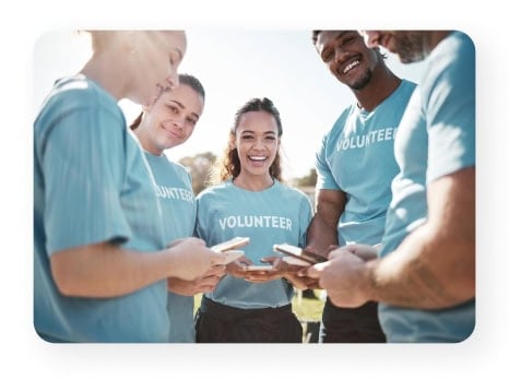 Group of volunteers using smartphones, representing teamwork, communication, and nonprofit organization support.