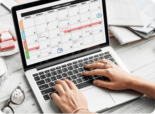 Person scheduling appointments on a digital calendar using a laptop, illustrating efficient appointment management.