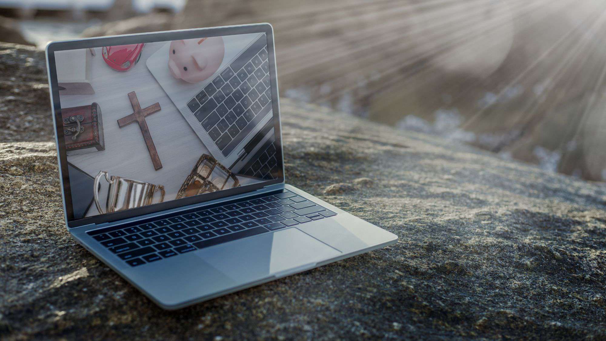 Laptop on a rock with a screen displaying church-related items, symbolizing digital outreach strategies for churches.