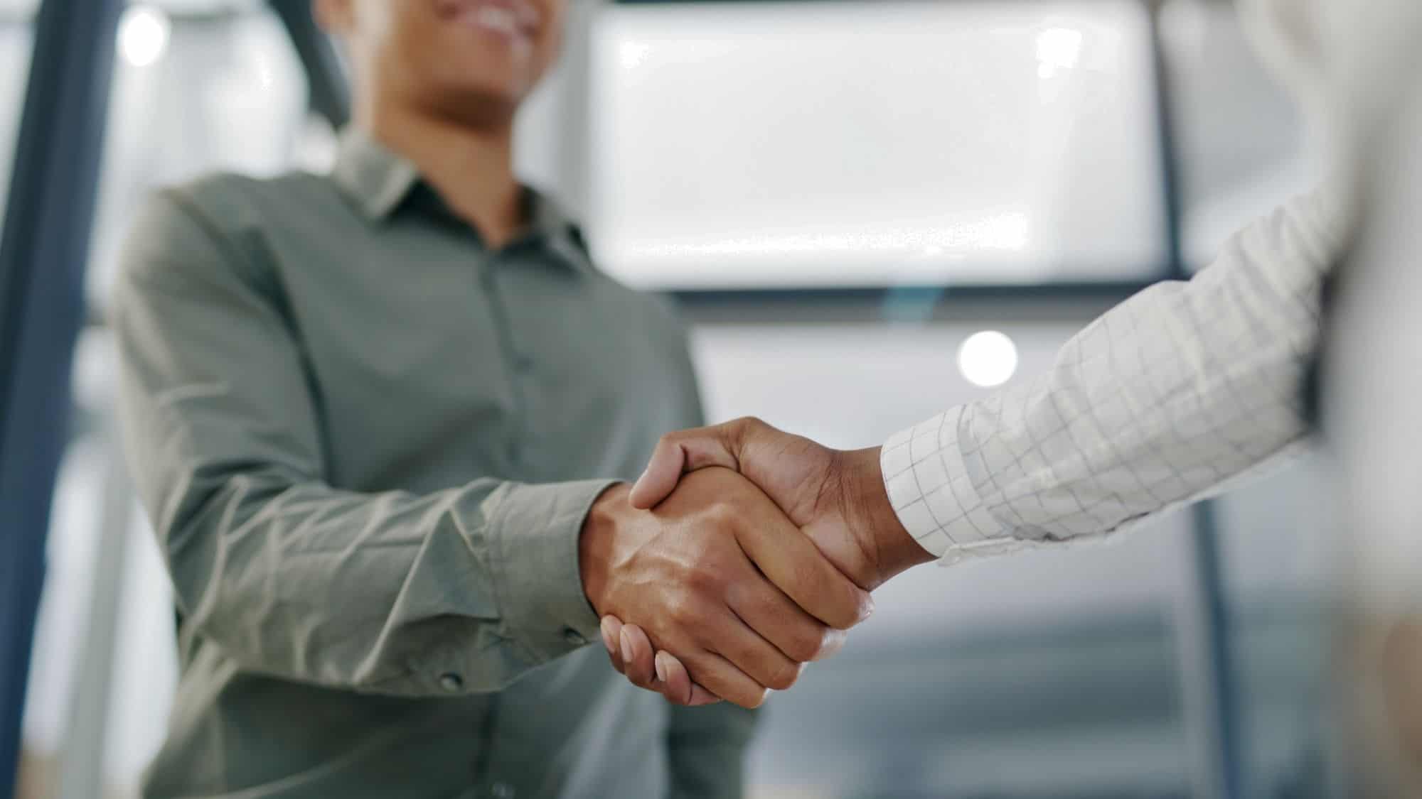 Two people shaking hands, symbolizing a successful onboarding process and building strong partnerships.